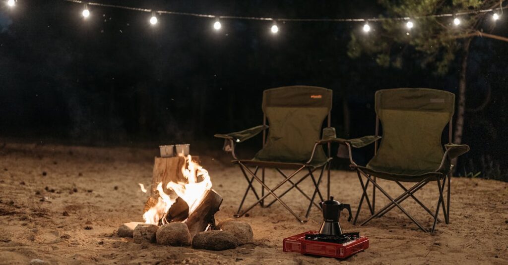 Outdoor camping scene with chairs and bonfire under string lights at night.